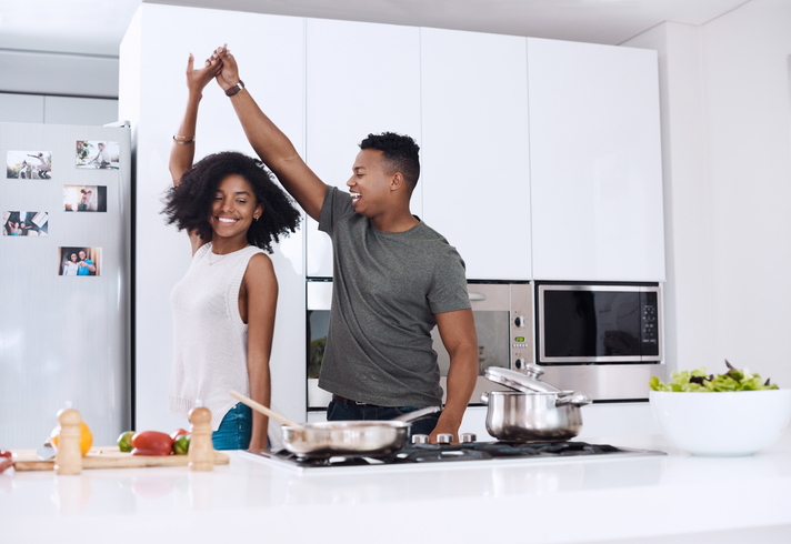 happy couple dancing in their kitchen