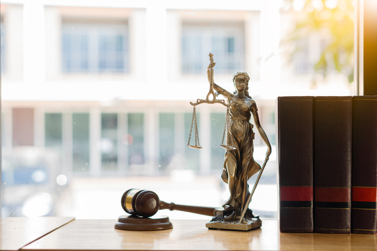 Judge's gavel with lady justice next legal books